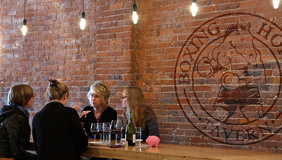 Inside of Boxing Horse Tavern with Sutter Group designed logo on the brick wall