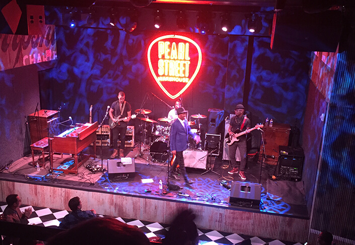 Booker T. Jones on stage at Pearl Street Warehouse in front of large lighted logo