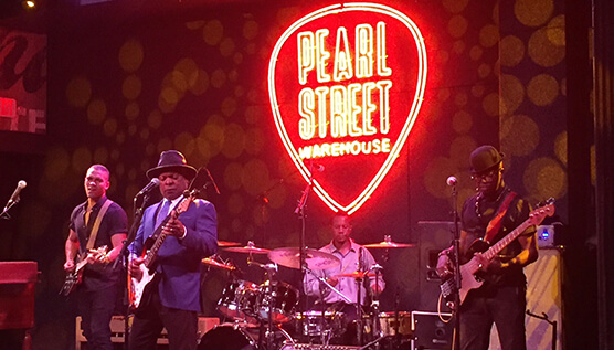 Booker T. Jones and his band performing at Pearl Street Warehouse with newly-designed logo behind them.