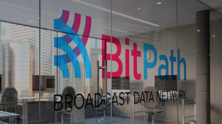 BitPath Broadcast Data Network logo on large glass lobby window with city view