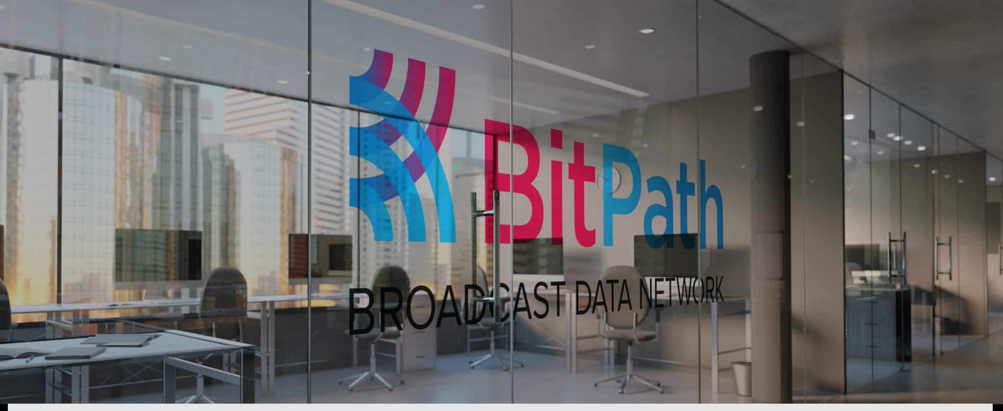 BitPath Broadcast Data Network logo applied to glass office wall with city skyline behind